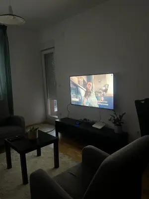 a living room with a flat screen tv on a wall at Apartman Perfectroom in Ivišovo Greblje