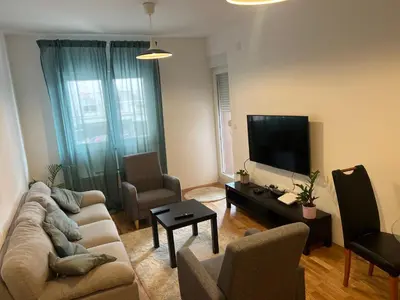 a living room with a couch and a flat screen tv at Apartman Perfectroom in Ivišovo Greblje