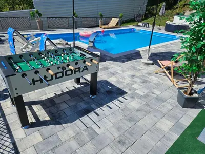 a foosball table in front of a swimming pool at Villa Harmonija