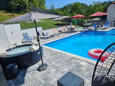 a swimming pool with a bathtub in the middle at Villa Harmonija