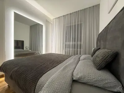 a bedroom with a large bed and a mirror at Apartman Luxury kod Kafeterije 5 i Wabi Sabi in Banja Luka