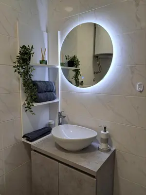 a bathroom with a white sink and a mirror at Apartman Luxury kod Kafeterije 5 i Wabi Sabi in Banja Luka
