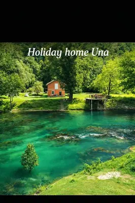 a sign that reads holiday home uniao next to a river at Holiday home Una in Bosanska Krupa