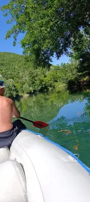 a man in a boat with a paddle on a river at Holiday home Una in Bosanska Krupa