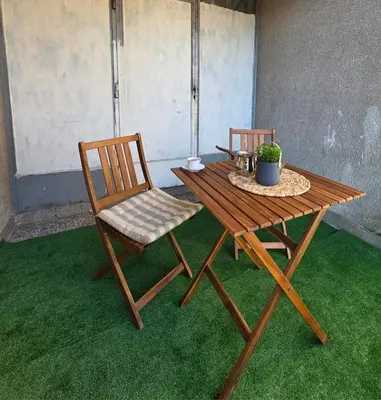 two chairs and a wooden table with a plant on it at Lux Una City in Bihać