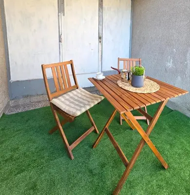 a wooden table and chair sitting on the grass at Lux Una City in Bihać