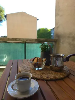 a cup of coffee and a bowl of muffins on a wooden table at Lux Una City in Bihać