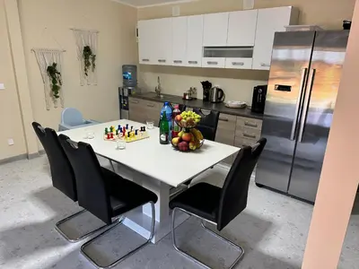 a kitchen with a white table with chairs and a refrigerator at Una Hacienda in Bihać