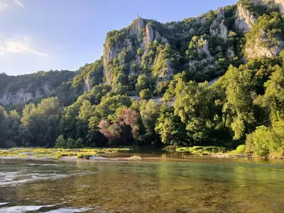 a river with trees and a mountain in the background at Max in Bihać
