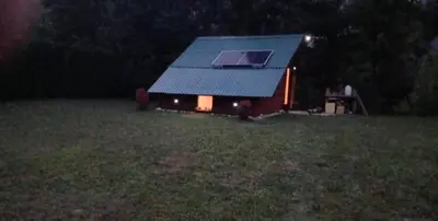 a small house with a window in a field at night at Max in Bihać