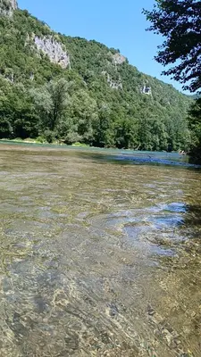 a body of water with trees and a mountain at Max in Bihać