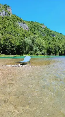 a bench sitting on the shore of a body of water at Max in Bihać