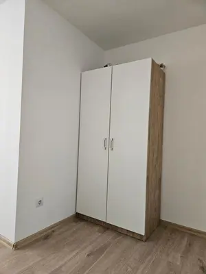 a white cabinet in a room with wooden floors at Jelena in Jajce