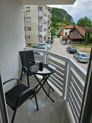 a table and chair on a balcony with a view of a street at Jelena in Jajce