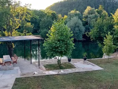 a garden with a gazebo next to a lake at Vikendica Šapat Sane, Prijedor