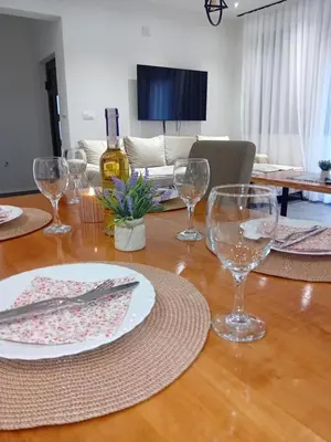 a table with wine glasses and a plate on it at Vikendica Šapat Sane, Prijedor