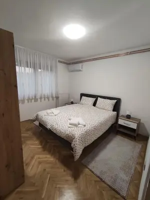 a bedroom with a bed with a black and white comforter at Apartman Lidija in Bihać