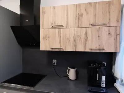 a kitchen counter with a coffee maker and wooden cabinets at Apartman Lidija in Bihać