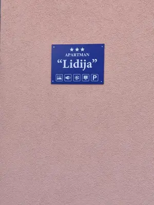 a sign for a library on a pink wall at Apartman Lidija in Bihać