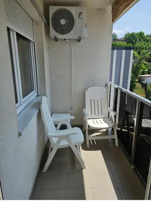 two chairs and a fan on a balcony at Comfort u blizini Klinickog Centra Banja Luka in Lauš