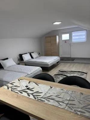 a room with two beds and two chairs in it at Apartman Studio EMA in Orašac