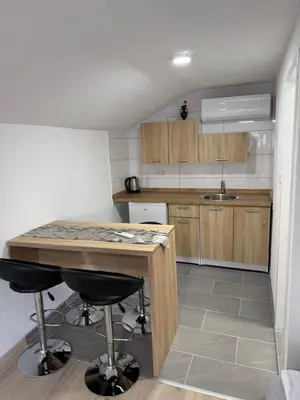 a kitchen with a table and two bar stools at Apartman Studio EMA in Orašac