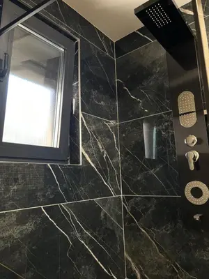 a bathroom with a black marble floor and a window at Villa Aurea in Bihać