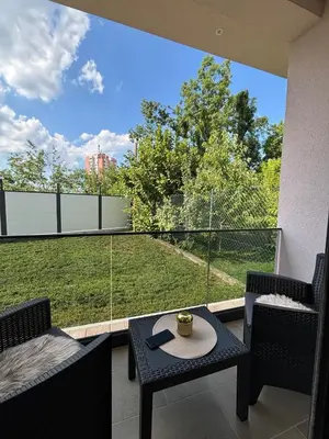 a balcony with a table and chairs and a large window at Villa Aurea in Bihać