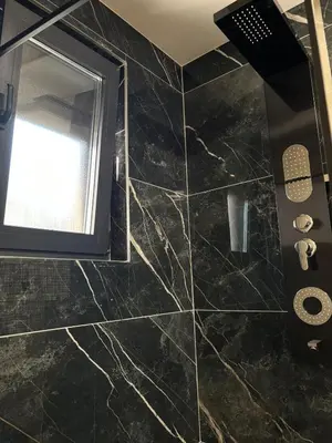 a bathroom with a black tiled floor and a window at Villa Aurea in Bihać