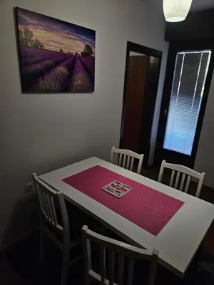 a dining room table with chairs and a picture on the wall at Apartman Maja in Bosanski Šamac