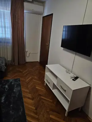 a living room with a tv and a white table at Apartman Maja in Bosanski Šamac