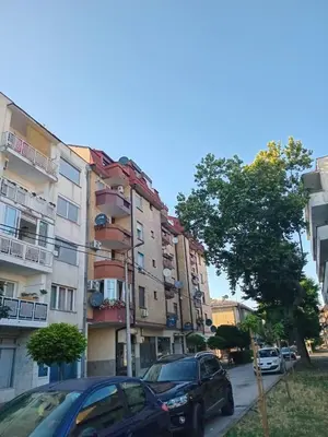 a street with cars parked in front of buildings at Apartman Maja in Bosanski Šamac