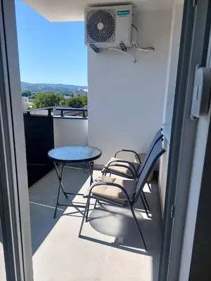 a balcony with a table and chairs and a fan at Apartman Sofia Doboj in Doboj