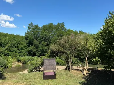 a chair sitting in the grass in a park at Villa Šašava in Bosanska Gradiška