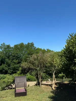a chair sitting in the grass in a park at Villa Šašava in Bosanska Gradiška