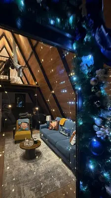 a living room with a blue couch and a christmas tree at Villa Šašava in Bosanska Gradiška