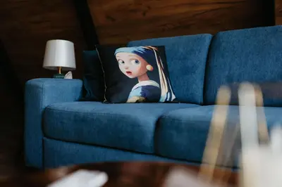 a doll on a pillow on a blue couch at Villa Šašava in Bosanska Gradiška