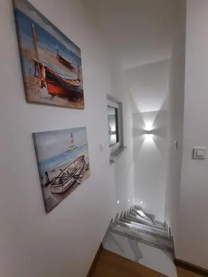 a white hallway with two paintings on the wall at Vikendica Dijana Ramsko jezero