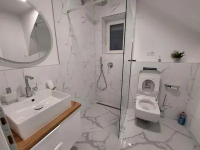 a bathroom with a sink and a toilet and a shower at Vikendica Dijana Ramsko jezero