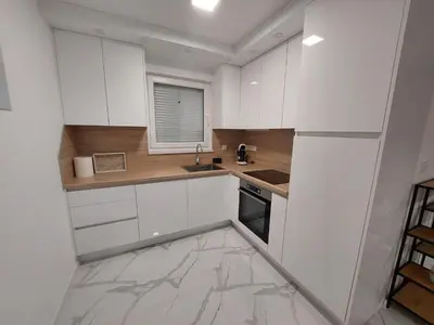 a kitchen with white cabinets and a sink and a window at Vikendica Dijana Ramsko jezero