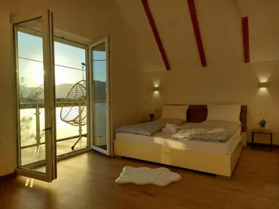 a bedroom with a bed and a large window at Vikendica Dijana Ramsko jezero