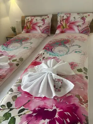 a bedroom with two beds with flowers on them at Vikendica Dijana Ramsko jezero