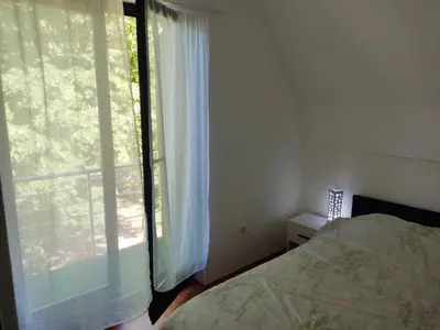 a bedroom with a bed and a large window at Villa Mostanica, Kozarska Dubica