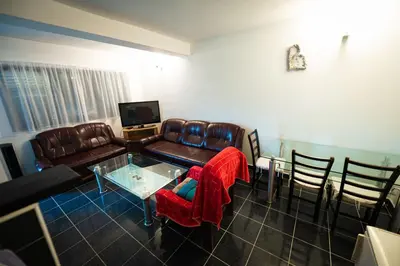 a living room with a couch and a table and chairs at Villa Mostanica, Kozarska Dubica