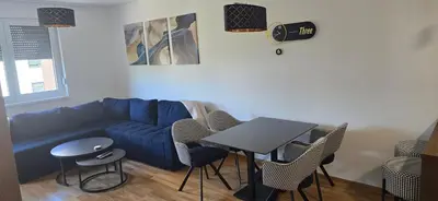 a living room with a blue couch and a table at Apartment Lazarus with garage Banja Luka in Banja Luka