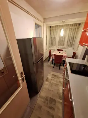 a kitchen with a refrigerator and a table with chairs at Nova varos apartman in Banja Luka