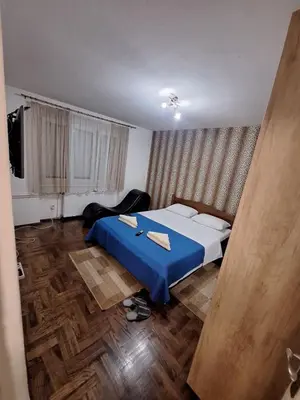 a bedroom with a bed with a blue blanket at Nova varos apartman in Banja Luka