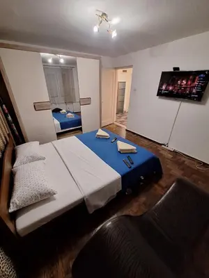 a bedroom with a large bed and a tv on the wall at Nova varos apartman in Banja Luka