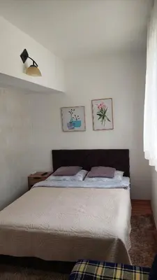 a bed in a bedroom with two pictures on the wall at Apartman Vlašićki san in Vlasic