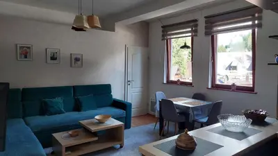 a living room with a blue couch and a table at Apartman Vlašićki san in Vlasic